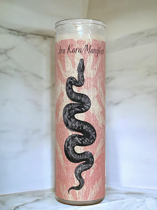 Candle with a snake design on a pink background, placed on a marble surface.