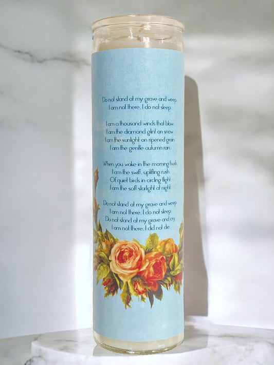 Candle with a blue label and floral design on a marble surface