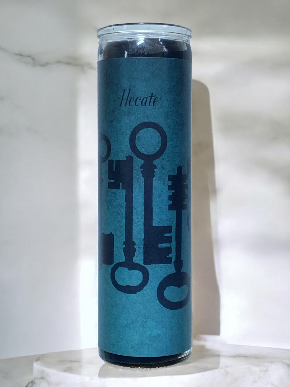 Blue candle with key designs on a marble surface