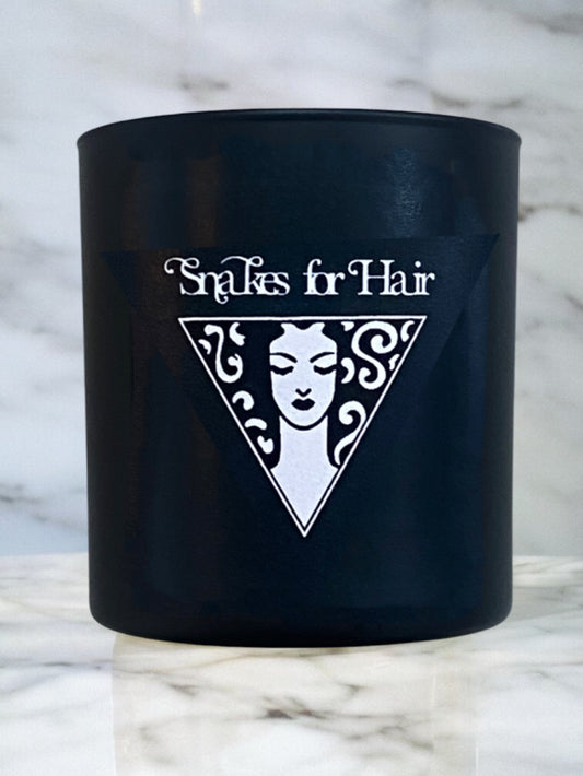 Black container with 'Snakes for Hair' logo on a marble background