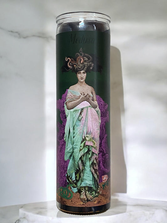 Candle with a design of Medusa on a dark background
