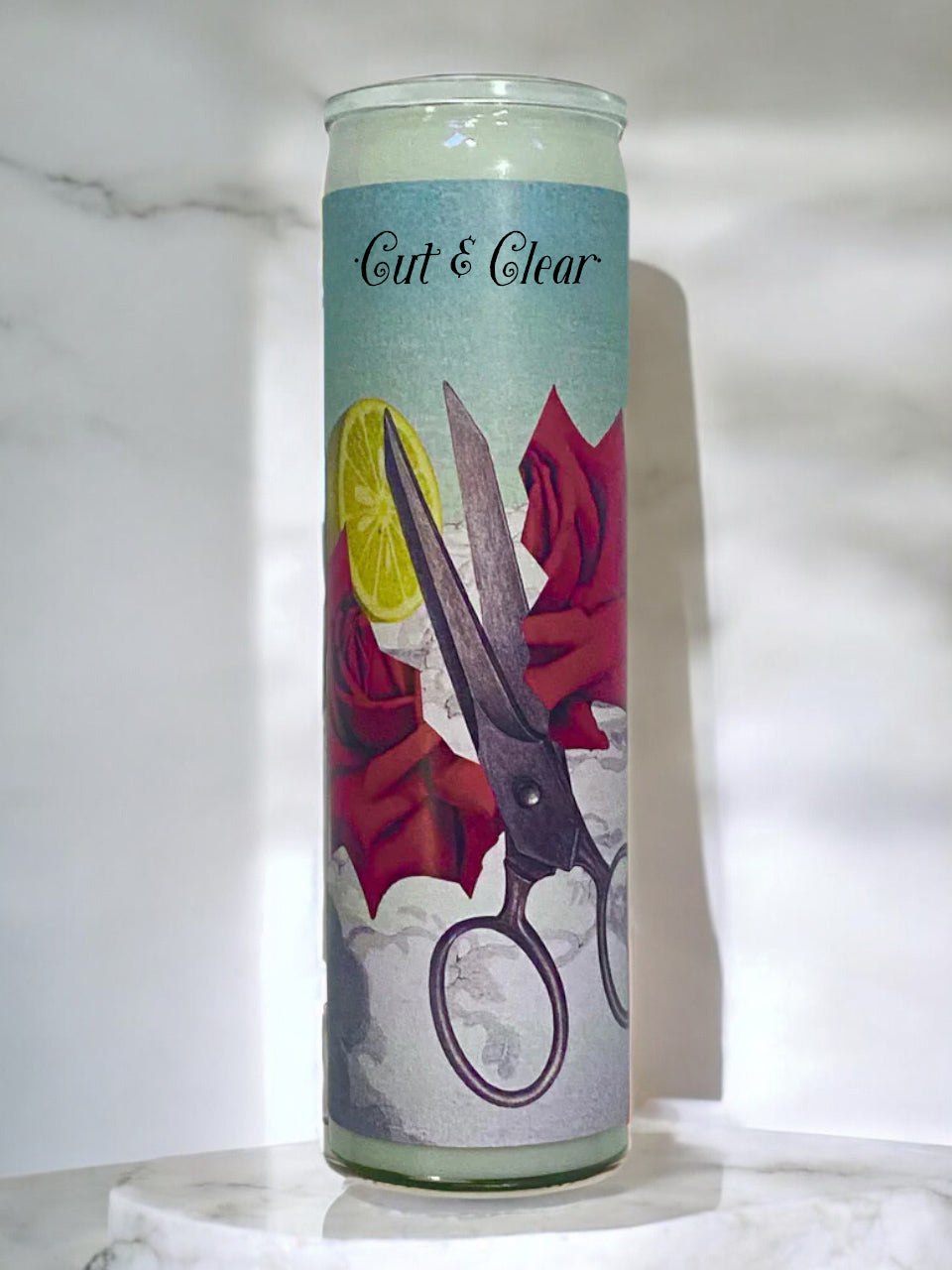 Candle with artistic design of scissors and roses on a light background