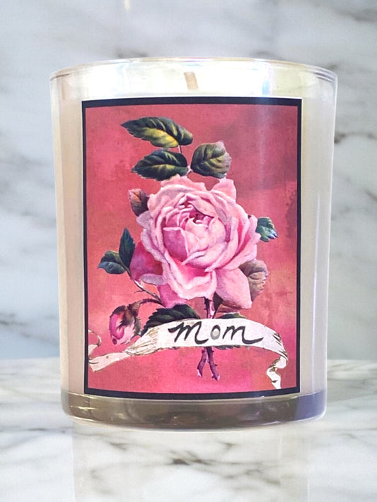 Candle with a pink rose design and 'mom' text on a marble surface
