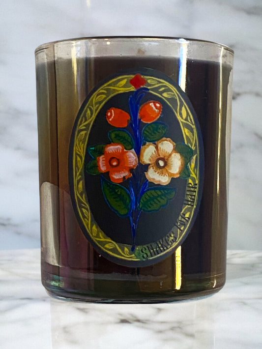 Decorative glass candle with floral design on a marble surface